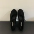 Close-up detail shot of black lace-up bow ballet flats, highlighting soft sole and inner tag. - 35 / Black