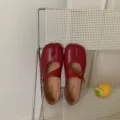 Vue détaillée de chaussures Mary Jane plates à bout fendu rouges sur chaise blanche. - 35 / Rouge