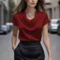 Vue de détail d'un élégant haut en satin rouge à col cowl et collier argenté étincelant. - S / Bordeaux