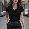 Vue détaillée de l'élégant chemisier noir en satin à col cowl et de son collier statement. - S / Noir