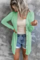 Vue détaillée du cardigan vert uni à manches longues et boutons dans une tenue décontractée. - S / Vert clair