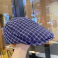 Primo piano del tessuto del berretto piatto a quadri blu e bianchi, dettagli vintage. - Berretto Newsboy a Scacchi / Blu Notte