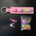 Detailed close-up shot of colorful plastic alphabet letter beads and custom DIY leather keychain accessory. - A-Z Set of 26 Letters / Light Color