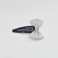Close-up detail of a sweet silver satin bow hair clip, cute black metal snap clip for girls. - Gray