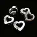 Primo piano di perline scorrevoli a cuore mezzo strass per braccialetti charm e creazione gioielli. - Cuore