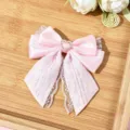 Pink satin lace bow hair clip featuring a sparkling rhinestone heart detail, close-up view. - Pink