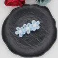 Detail shot of a sweet blue embroidered floral hair clip with three daisy motifs on a plate. - Light Blue Triple Flower (09#)