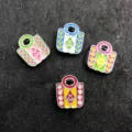 Detail view of four colorful 8mm enamel cartoon DIY charms with rhinestones on dark background. - Bags