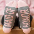 Bridesmaid socks detail showing pink printed text on grey sole, wedding party feet shot - Pink