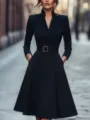 Close-up detail of the elegant black midi dress featuring V-neck and stylish gold buckle belt. - S / Dresses / Black