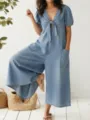 Detail shot of the stylish V-neck puff sleeve denim jumpsuit featuring large pockets. - S / Light Blue