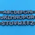 Close-up detail of blue rhinestone alphabet letter charms for DIY jewelry making accessories. - Letter A / Ink Blue