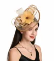 Detailed view of the elegant beige mesh fascinator hat, showcasing delicate feather and loop design. - Gold