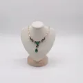 Detailed view of exquisite green crystal pendant necklace on jewelry display mannequin bust. - S / Beige