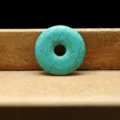Pendentif donut en turquoise synthétique avec texture craquelée, vue détaillée du bijou. - 30mm