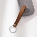 Bruine lederen sleutelhanger riem met metalen ring, stijlvolle tassenhanger accessoire. - koffiekleur