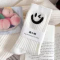 White ribbed mid-tube socks featuring a chic black rhinestone winking smiley face design. - One Size (EU 34-39) / White