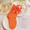 Kids orange mid-tube socks featuring a cute fluffy plush monster doll with sunglasses decor. - L: 18-20 (Ages 6-8, EU 26-31) / Orange Socks with Orange Pompoms