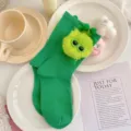 Cute green crew socks for girls featuring a fuzzy fluffy monster doll with funny sunglasses. - Green Socks with Green Pompoms