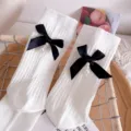 White cotton mid-tube socks featuring elegant black ribbon bows and pearl pendants, stylish and cozy. - One Size (EU 34-39) / White