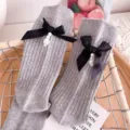 Grey ribbed mid-calf socks designed with a chic black bow and hanging pearl pendant details. - One Size (EU 34-39) / Light Gray