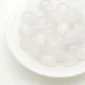 Primo piano di perline rotonde in resina glitterata traslucida per artigianato e fai da te. - 8mm / Bianco