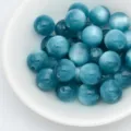 Gros plan de perles rondes en résine effet œil de chat bleu foncé pour bijoux DIY. - 8mm / Bleu d'Hiver