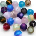Primo piano di perline colorate effetto occhio di gatto, perfette per creazioni di bigiotteria. - Multicolore