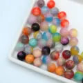 Dettaglio perline tonde in resina marmorizzata colorata, perfette per braccialetti e ciondoli fai da te. - 10 mm / dimensione del foro circa 1,8 mm / Multicolore