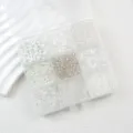 Nahaufnahme von gemischten Glasperlen in einer transparenten Aufbewahrungsbox für DIY-Schmuck. - Weißes Gitter