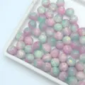 Close-up detail of gradient pink and mint green resin beads, perfect for DIY jewelry craft. - Cyan and Purple