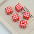 Close-up of red and white checkered square acrylic beads, perfect for DIY handmade jewelry details. - Bright Red Plaid