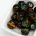 Gros plan de perles jelly œil-de-chat 12mm, montrant une surface lisse et des couches colorées. - 15. Vert foncé de rêve