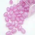 Vue détaillée de perles ovales en résine violette pailletée sortant d'une boîte, pour bijoux DIY. - 8x11mm / Mauve Clair
