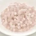 Close-up of 4mm pink cat-eye glass seed beads, ideal for DIY handmade bracelets and crafts. - 4mm / Champagne