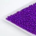 Purple glass seed beads in white tray for DIY handmade bracelets and jewelry accessories. - Deep purple