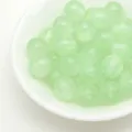 Light green glitter resin round beads detail shot, perfect for DIY jewelry making and crafts. - Green