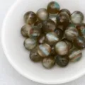 Close-up detail of dreamy jelly cat eye round beads in white bowl for handmade DIY jewelry. - 8. Dreamy Brownish Green