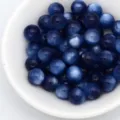 Dettaglio ravvicinato di perline rotonde in resina blu scuro con effetto occhio di gatto. - Blu Cobalto