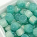 Close-up of cyan resin barrel beads with gilded finish, perfect for DIY jewelry and crafts. - 8x10mm/Hole Size Approx. 1.6mm / Gilded - Green