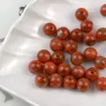 Closeup detail shot of red imitation lacquer resin round beads for DIY jewelry making. - Warring States Red Agate