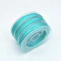Close-up detail of cyan jade cord rolled on a clear spool, perfect for DIY jewelry and crafts. - 0.8mm (Approx. 10m) / Azure Blue