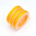 Detailed view of bright yellow nylon cord on spool, perfect for DIY jewelry making and crafting. - 0.8mm (Approx. 10m) / Orange Yellow
