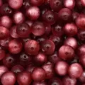 Close up detail of red resin cat eye beads, perfect for DIY jewelry making and crafts. - Burgundy