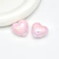 Detailed shot of pink iridescent acrylic balloon heart beads with embossed letters for DIY jewelry. - Pink