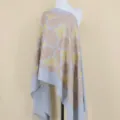 Detailed view of light blue cashmere shawl with gold floral embroidery and stylish fringe edge. - Light Blue