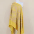 Close-up of yellow cashmere shawl with intricate gold embroidery and elegant tassel details. - Yellow