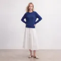 Detailaufnahme des eleganten blauen Pullovers mit Rundhalsausschnitt und weißem Rock. - S / Blau