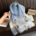 Detail geborduurde zijden sjaal, elegant blauw bloemendesign op doorschijnende stof, luxe accessoire. - Blauw