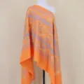 Gedetailleerd overzicht van oranje kasjmiergevoel sjaal met elegant paisley borduurpatroon. - Lichtoranje